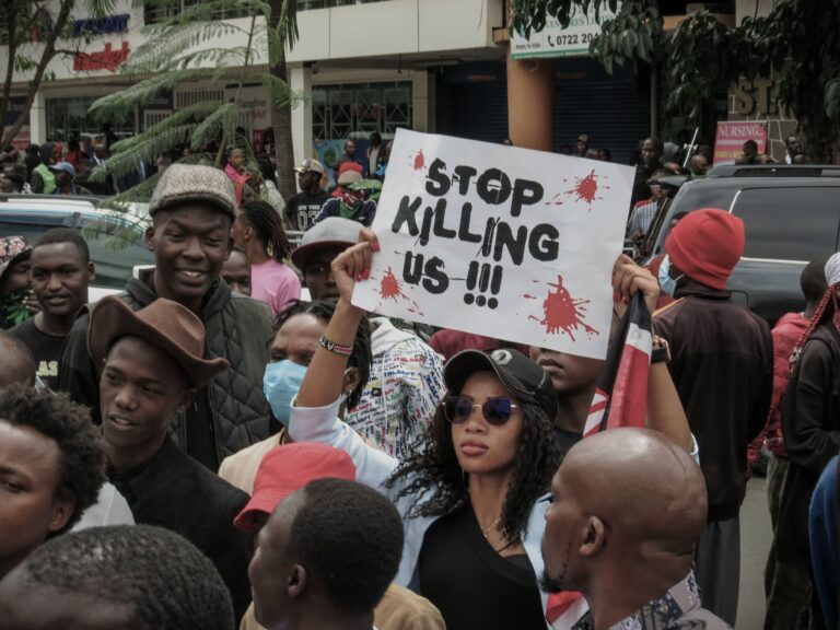 African woman holding a protest sign against violence and police brutality