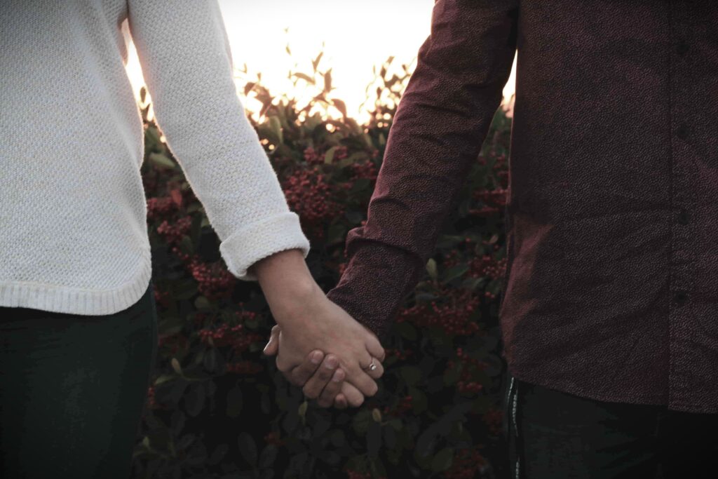 Couple holding hands, symbolising love and connection, promoting healthy relationships and mental well-being.