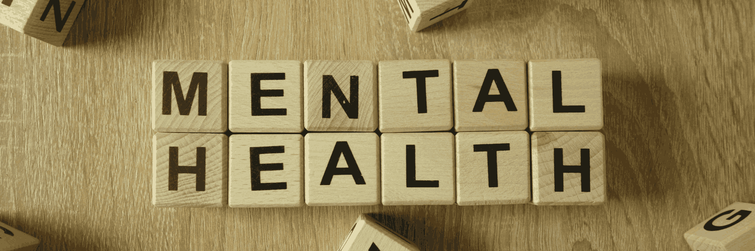 Wooden scrabble blocks spelling out mental health for an A-Z mental health dictionary